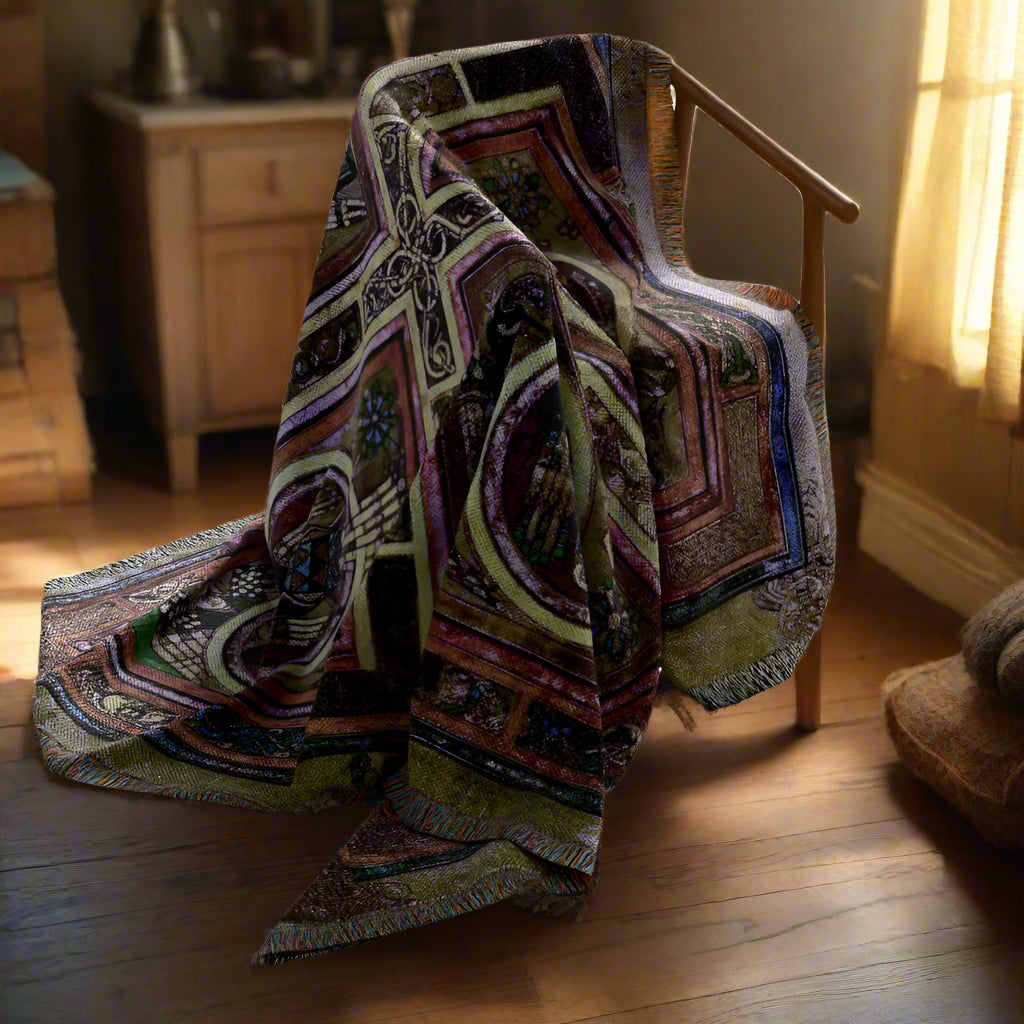 Patterned blanket draped over a wooden chair on a white background