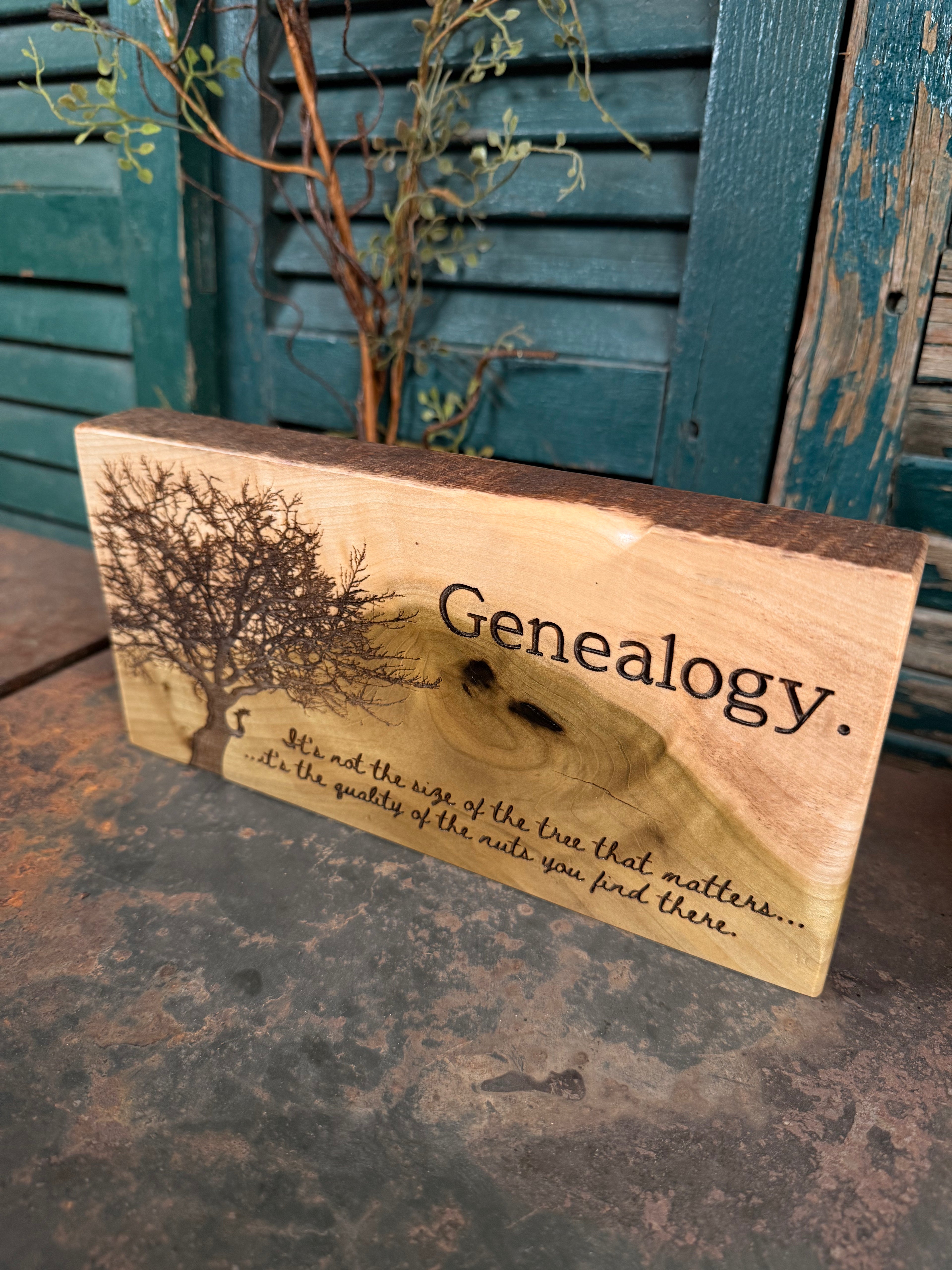 Wooden block with 'Genealogy' and a tree engraving on a rustic surface.