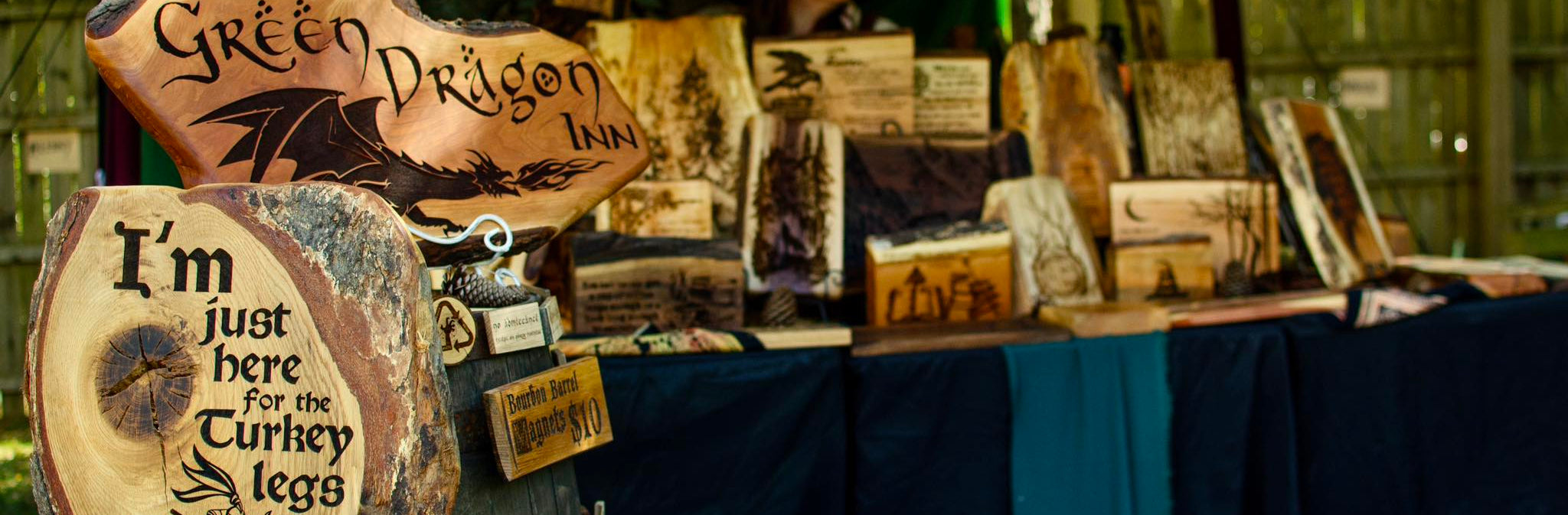 Vendor booth with wooden signs and products at an outdoor event